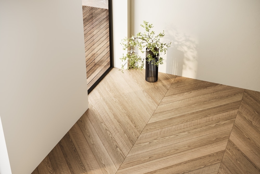 Parquet Chevron en Chêne : Design Intérieur Moderne Parquet en chêne motif chevron dans un intérieur moderne lumineux avec plante décorative et mur blanc.